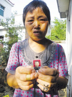 鮑祥義的妻子展示丈夫遺照。