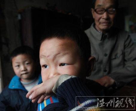 毛坪村的小男孩袁石(中)，告訴記者，他的妹妹袁麗一歲的時候，被搶走了，至今下落不明。他想念妹妹，多次夢到她回家了。 記者 李漠 攝