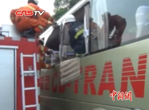 消防隊員幫助被困人員爬出車廂