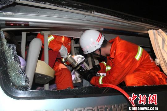 消防人員在對(duì)變形車(chē)廂進(jìn)行破拆