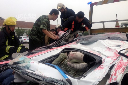 青島轎車被集裝箱壓扁車內(nèi)兩人奇跡生還