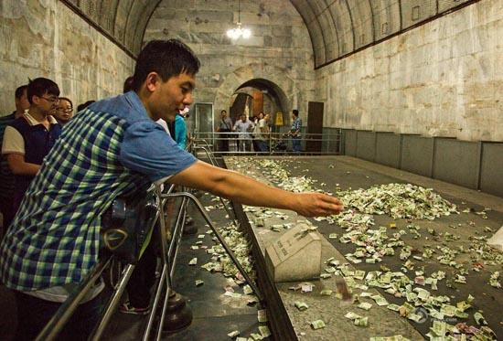 北京十三陵地宮內(nèi)堆滿游客扔的祈福紙幣