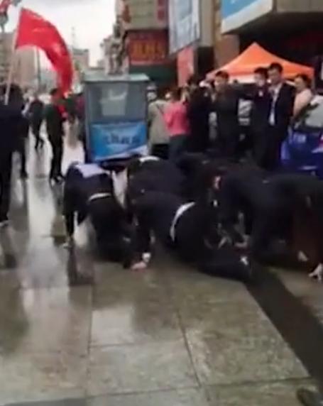 員工當(dāng)街下跪爬行