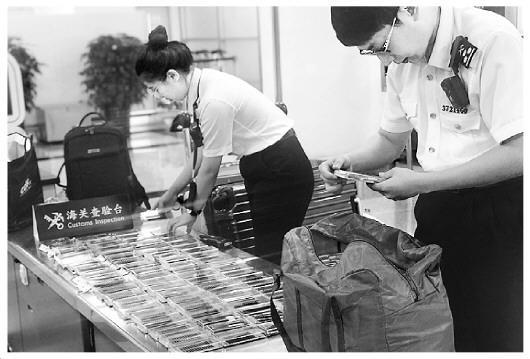 圖為海關(guān)工作人員在檢查旅客攜帶的假睫毛。王詠潔 攝 